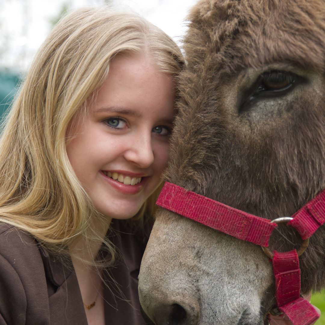 meisje knuffelt met een ezel